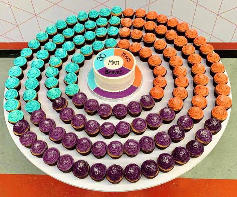 A colourful cake display to mark Matt's long-running service, in brand colours